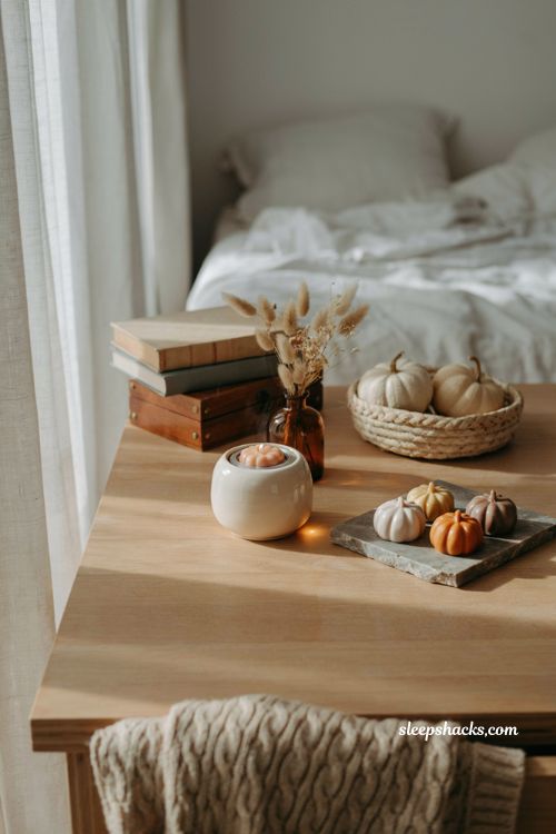 Pumpkin wax melt trio with ceramic warmer in a cozy autumn bedroom for soft fall home fragrance