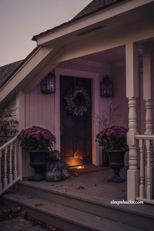 Purple LED lights with black urns purple mums and charcoal pumpkins for Halloween porch decor