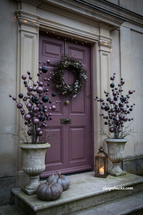 Purple and black glitter Halloween garland with jewel tone balls on a front porch 