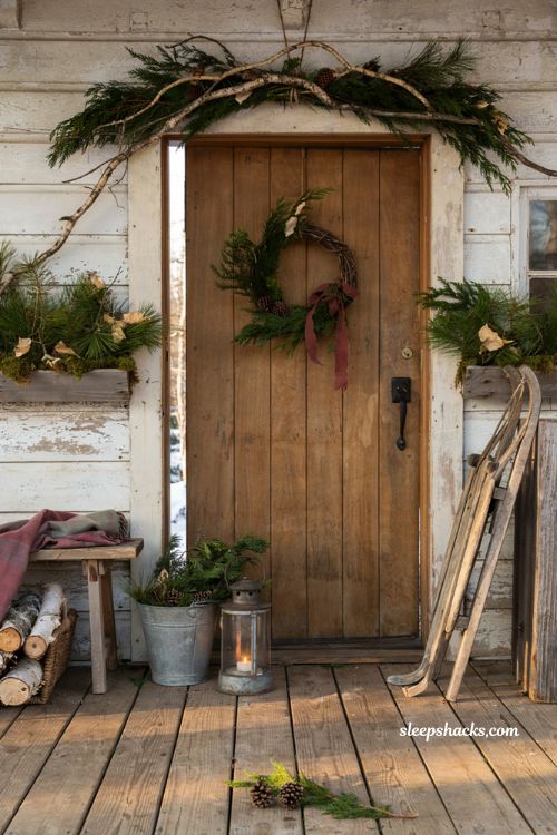 Rustic christmas front porch with foraged evergreen branches and natural mountain cabin holiday decor