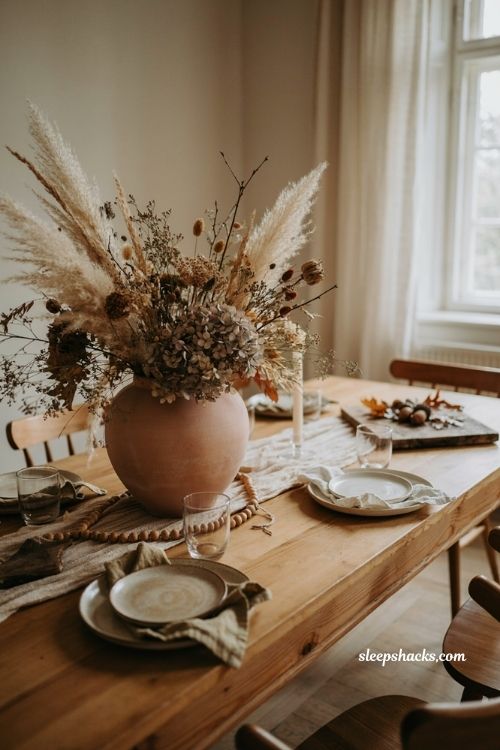 Rustic fall dining table decor with dried floral arrangement wooden beads and natural textures 