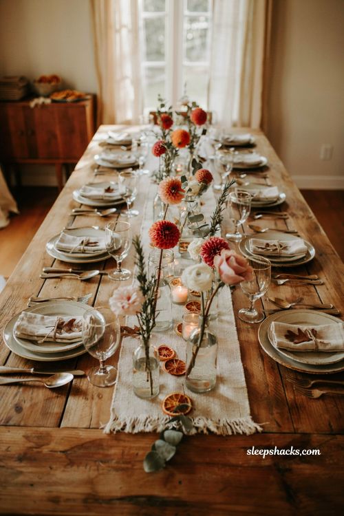 Simple and charming fall baby shower centerpiece idea with single stem dahlias and roses in assorted bud vases on a jute runner