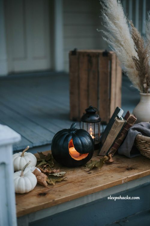 Simple crescent moon pumpkin carving idea with black painted pumpkin for cozy Halloween porch decor