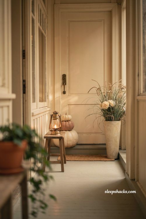 Simple fall front porch ideas for small spaces with vertical pumpkins tall planter and lantern 