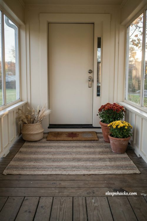 Simple fall front porch ideas with layered outdoor rug and seasonal doormat 