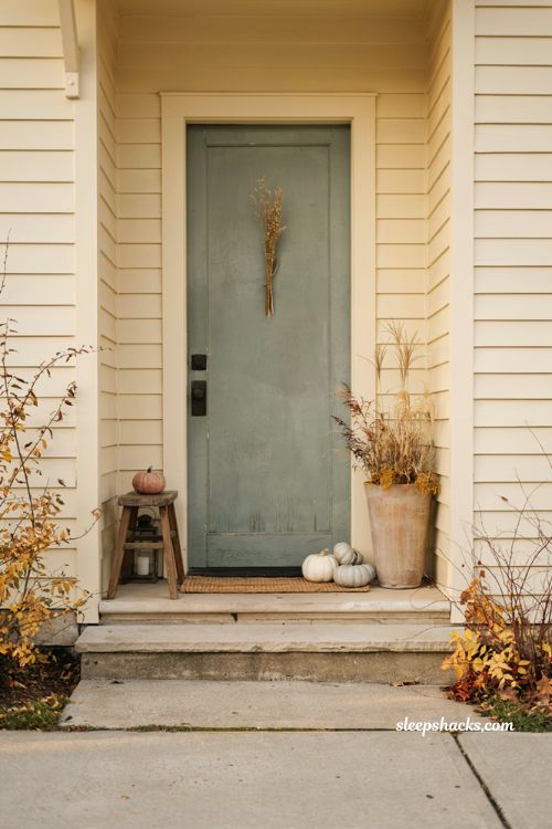 Simple small front porch fall decor ideas with pumpkins and natural textures