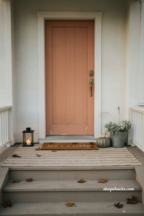 Simple small front porch fall decor with layered rug and seasonal doormat