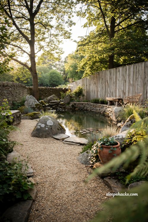 Small natural pool with rustic stone edging and organic backyard landscaping