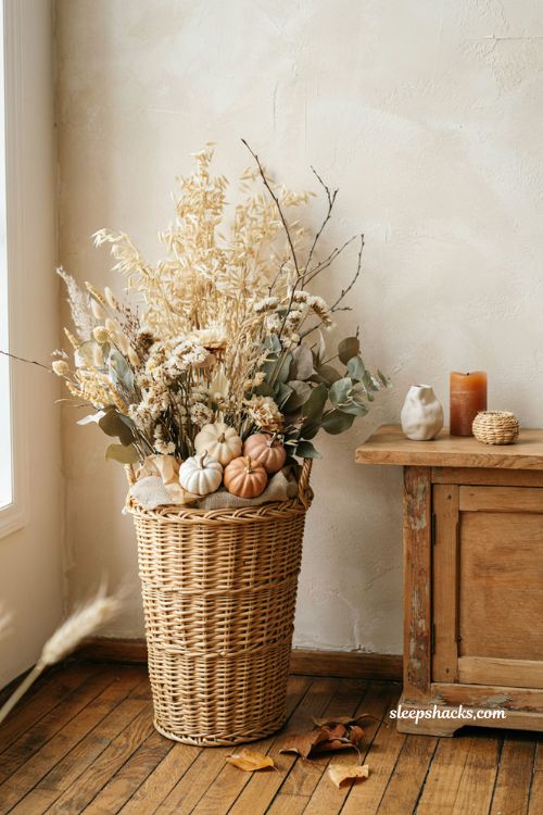 Tall wicker fall basket with layered florals dried wheat stems and pumpkins