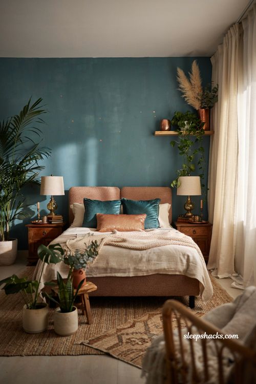 Teal and copper bedroom with lush plants and natural boho decor