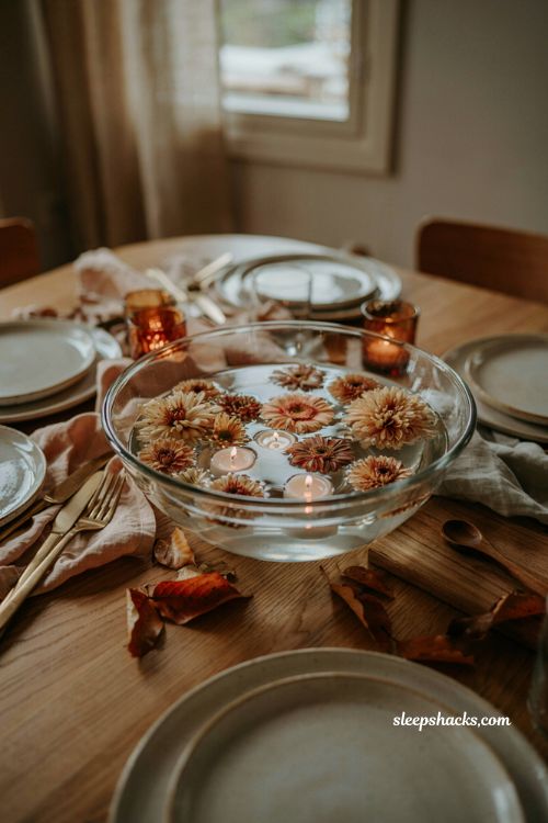 Thanksgiving flower arrangement with floating blooms and candles in glass bowl 