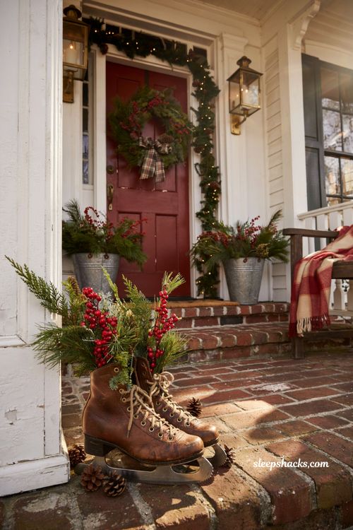 Traditional christmas porch decor with vintage ice skates filled with greenery and berries