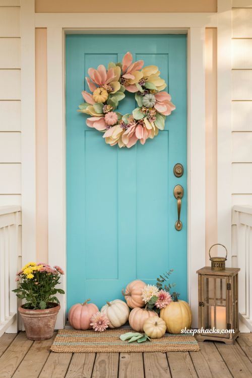 Turquoise and blush Halloween front door with pastel wreath pumpkins and flowers