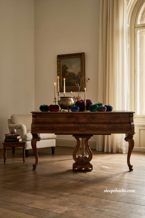 Velvet pumpkin Halloween living room decor with jewel tones, piano, candles, and elegant accents 