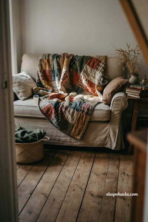 Vintage fall decor with a handmade quilt draped over a cozy couch