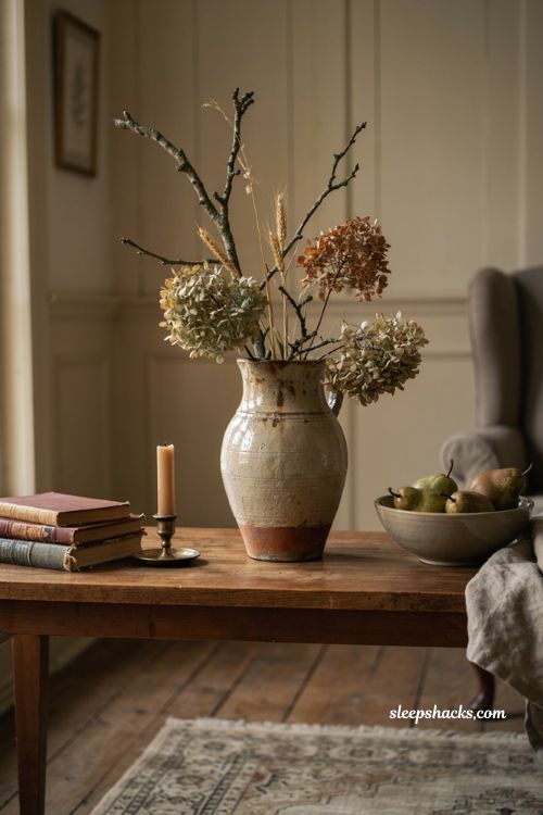Vintage fall decor with an old pitcher filled with dried branches