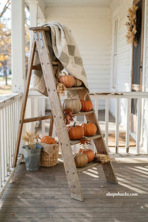 Vintage fall porch decor with old wooden ladder and mini pumpkins