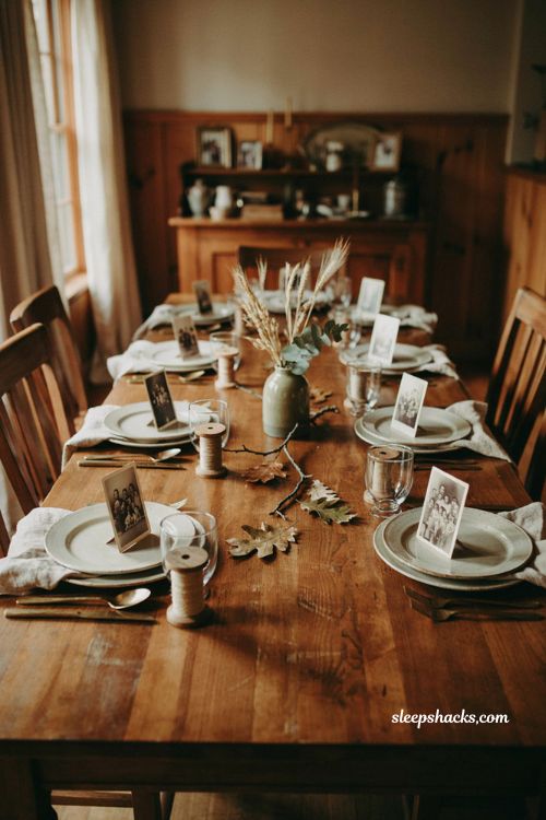 Vintage photo Thanksgiving place cards with wooden spool holders cream plates linen napkins and nostalgic autumn table decor 
