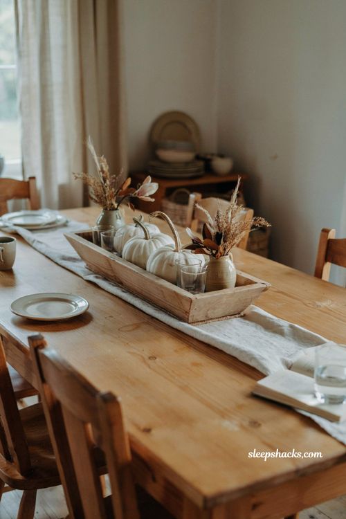 White pumpkin centerpiece in a shallow wooden trough for an easy fall table display 
