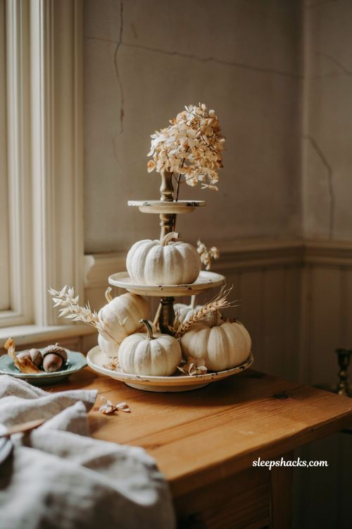 White pumpkin centerpiece on a vintage tiered cupcake stand with dried hydrangea