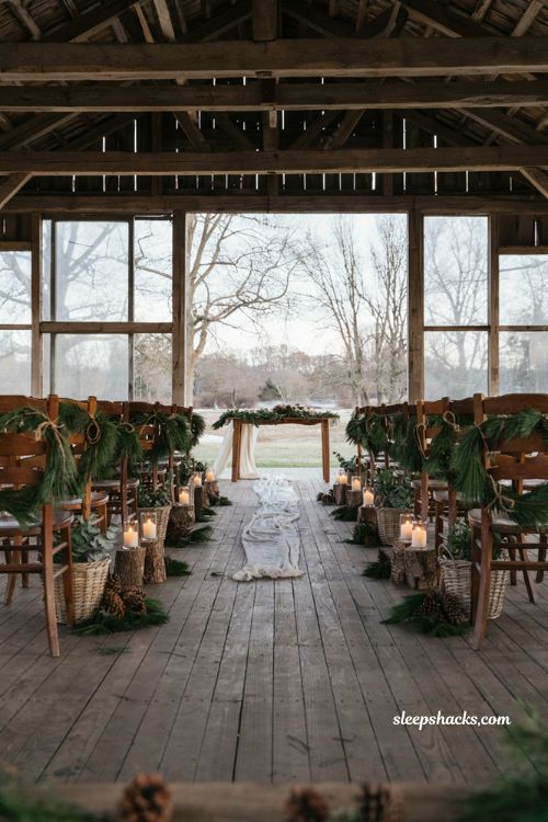 Winter wedding aisle decor with pine greenery pinecones log slices and candles