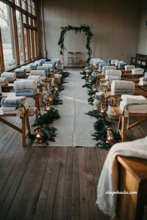 Winter wedding blanket favors with cozy ivory throws and soft blue ceremony seating