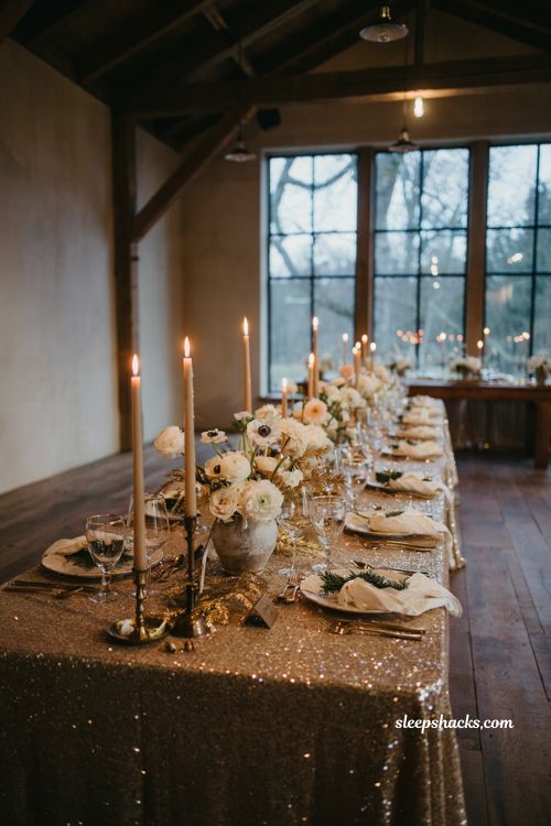 Winter wedding table decor with gold sequin linens white flowers and candlelight
