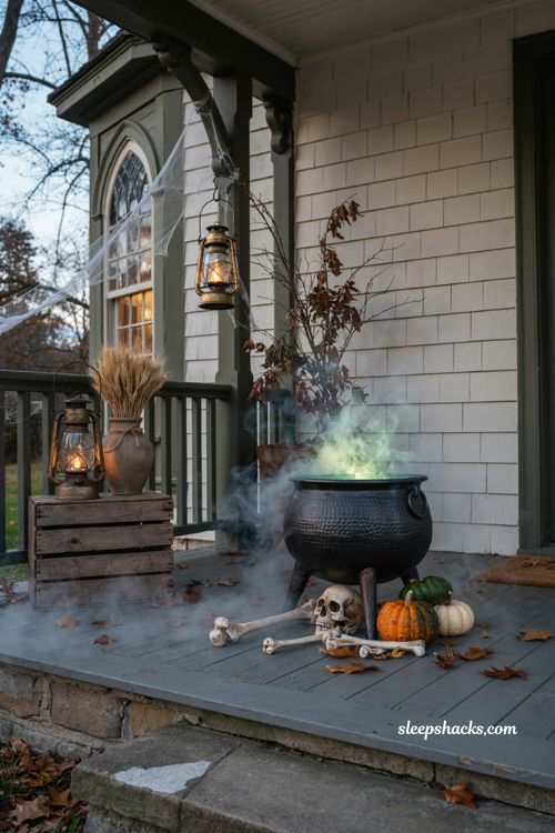 Witchs cauldron Halloween scene with glowing green mist skulls pumpkins and cozy porch decor