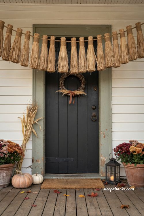 Witchy broom garland across a farmhouse front door for Halloween