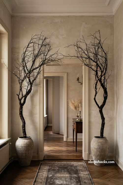 classy halloween decor with black branches and warm lights in an elegant entryway