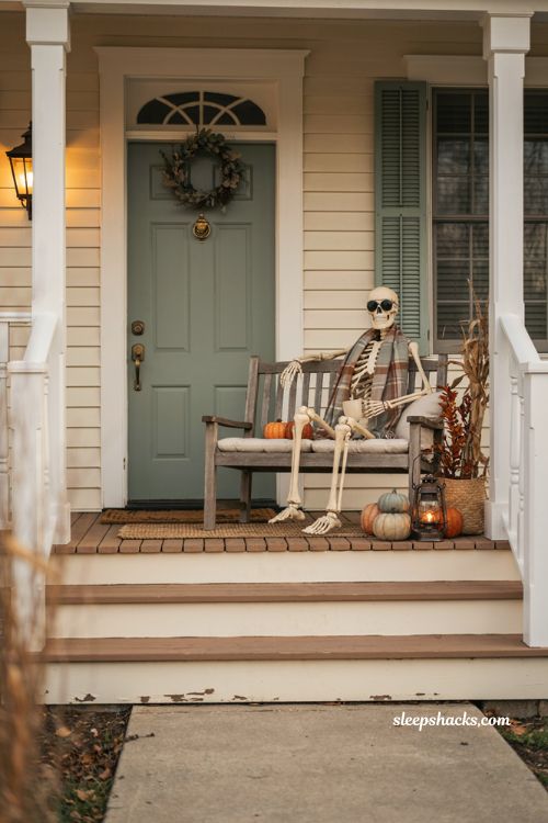 cute halloween porch decor with a playful skeleton on a porch swing