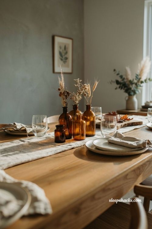 fall dining table decor with amber glass bottles and vintage vessels