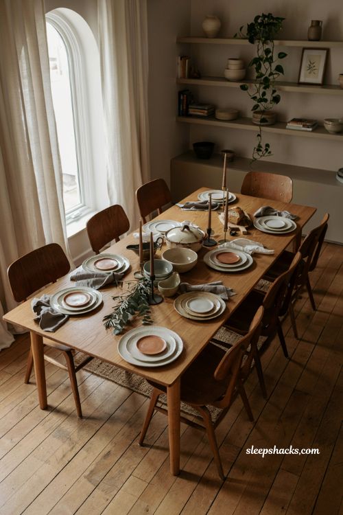 modern Thanksgiving table with warm neutral colors contemporary holiday dining decor natural wood handmade ceramics linen napkins minimalist fall centerpiece cozy elegant Thanksgiving tablescape