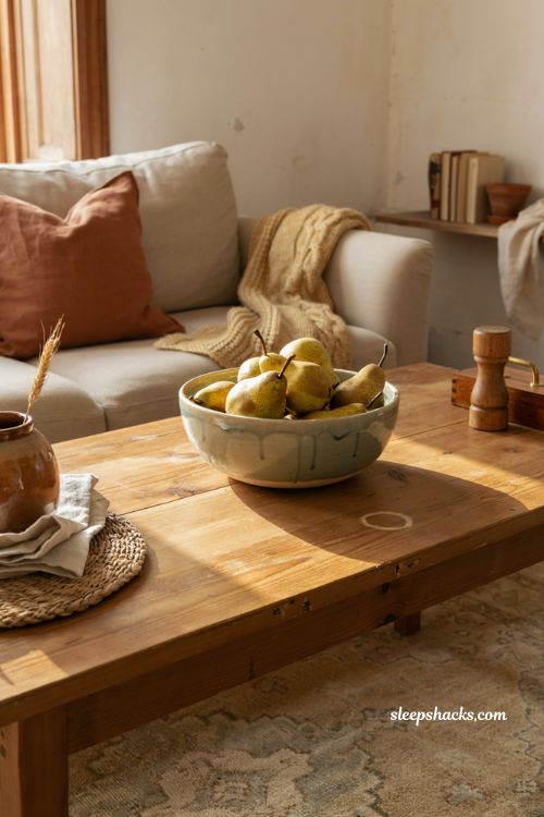 rustic bowl of golden faux pears on a coffee table with warm fall decor