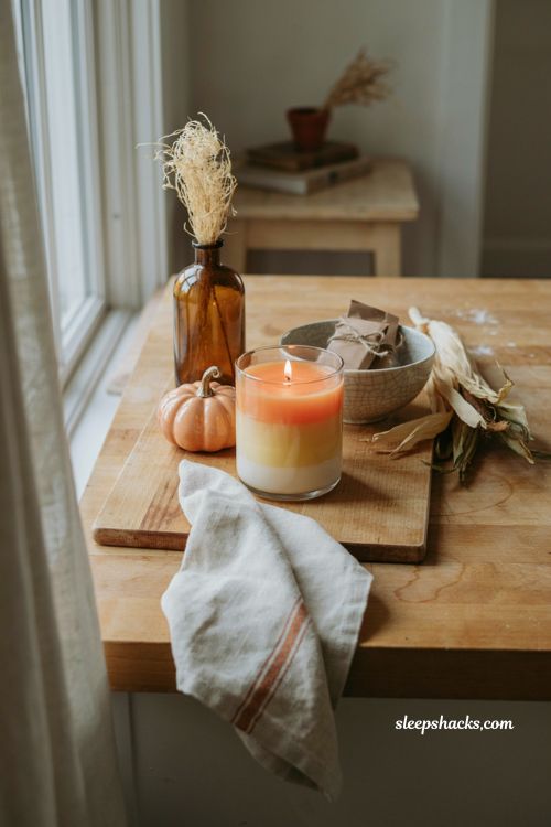 ```text Candy corn scented Halloween candle with orange yellow and white layered wax on a cozy cottage kitchen counter, nostalgic pumpkin decor, vintage ceramic bowl, aged wooden cutting board, dried corn husks, warm linen towel, soft natural window light, playful autumn atmosphere, cheerful Halloween styling, cozy lived in kitchen, photorealistic editorial interior photography, Pinterest-worthy ``` 