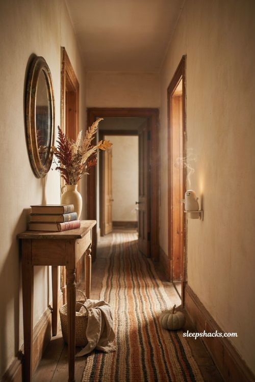 ```text Halloween scent diffuser in a cozy vintage cottage hallway, small ceramic ghost inspired plug in diffuser, weathered console table, antique brass mirror, woven basket, old hardcover books, dried autumn stems, vintage ceramic vase, neutral pumpkin, natural linen, aged wood trim, soft afternoon window light, warm cream and muted pumpkin palette, subtle seasonal decor, peaceful nostalgic Halloween atmosphere, photorealistic editorial interior photography, Pinterest-worthy ``` 
