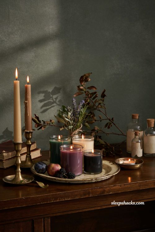 ```text id="q2v6hc" Witches brew themed Halloween candles in deep purple and forest green glass arranged on a vintage tray, elegant gothic apothecary shelf, antique brass holders, dried herbs and orchard branches, dark autumn fruits, aged wooden books, rustic ceramic vessels, warm amber candlelight, sophisticated moody Halloween decor, vintage cottage interior, mysterious cozy atmosphere, photorealistic editorial interior photography, Pinterest-worthy ```