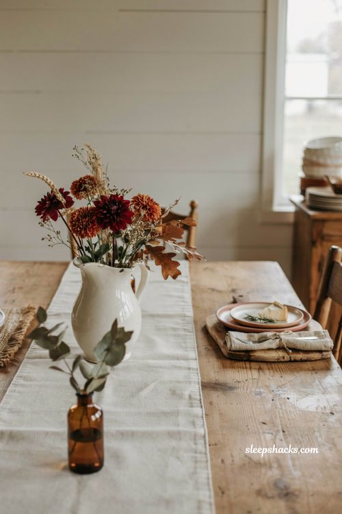 white ironstone pitcher fall centerpiece ideas with rustic autumn flowers and table decor