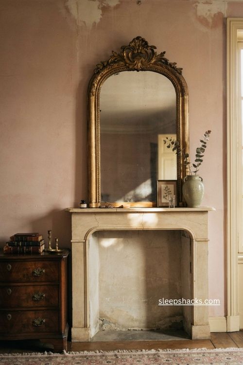 Antique mirror with ornate aged frame above a vintage fireplace mantel 