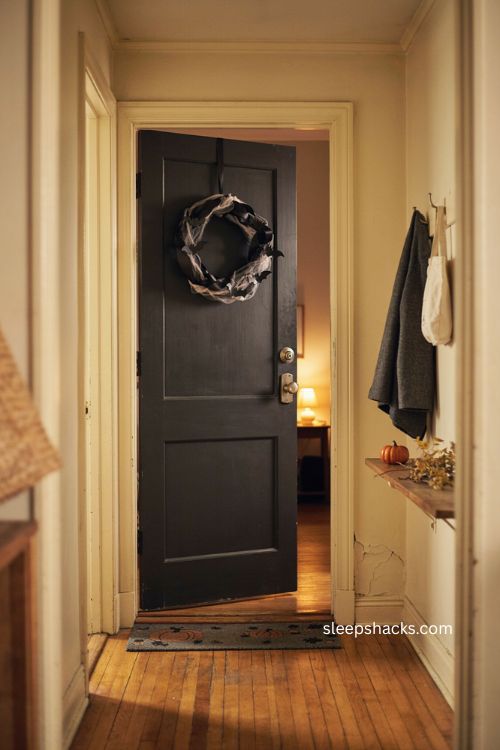 Apartment Halloween front door decor with black wreath and bats 