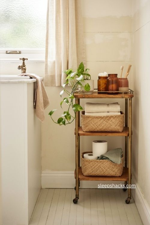 Bathroom rolling bar cart storage with baskets towels toilet paper and toiletries 