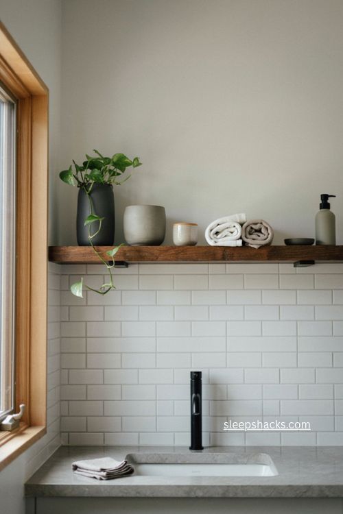 Bathroom shelves with dark wood floating shelf white tile and pottery 