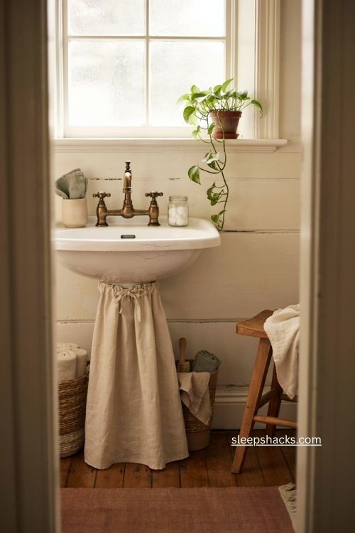 Bathroom sink skirt storage with hidden baskets under a pedestal sink 