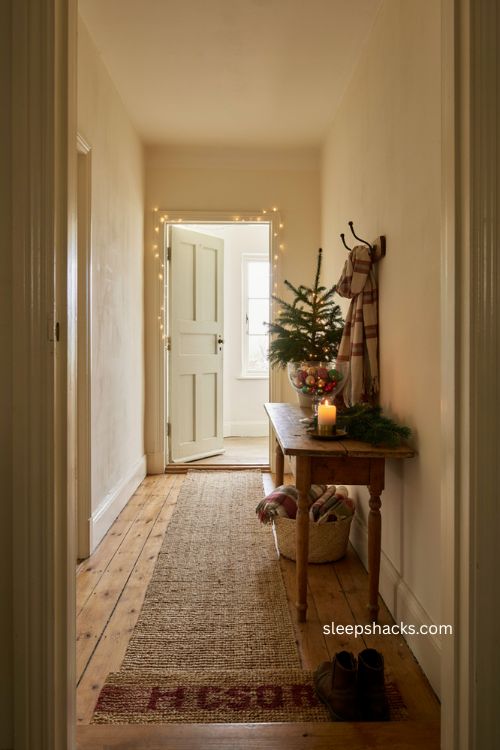 Beautiful christmas entryway decor with mini tree ornaments plaid scarf and warm candlelight 