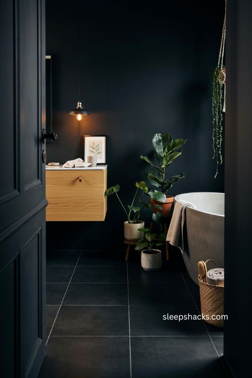 Black bathroom with green plants floating wood vanity and warm pendant lights