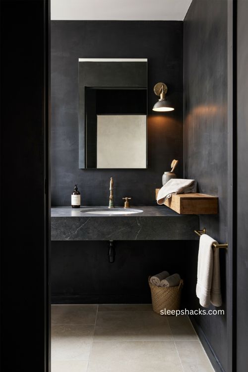 Black industrial bathroom with distressed brass hardware wood shelf and mirror