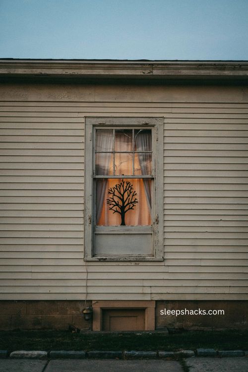 Black paper tree silhouette in upstairs window for minimalist Halloween decor