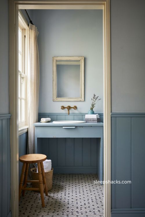 Blue bathroom with soft powder blue walls vintage vanity and calming cozy details 