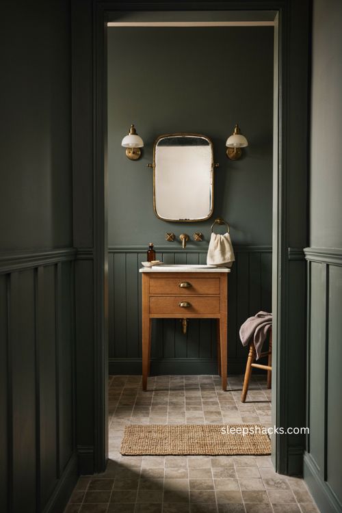 Brass hardware moody bathroom with dark walls vintage vanity and warm metallic accents 