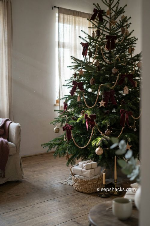 Burgundy velvet bows with natural wood ornaments on Christmas tree 